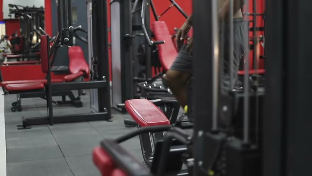 A young black man comes to the gym and prepares for a workout.