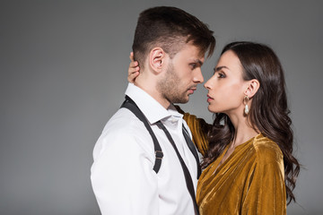 beautiful tender couple hugging and looking at each other isolated on grey