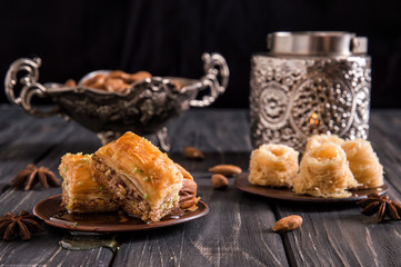 Close up. Eastern still life. Turkish traditional honey baklava, nuts. Dark wooden background.