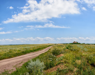 Fototapeta na wymiar Field road to the steppe beyond Donetsk