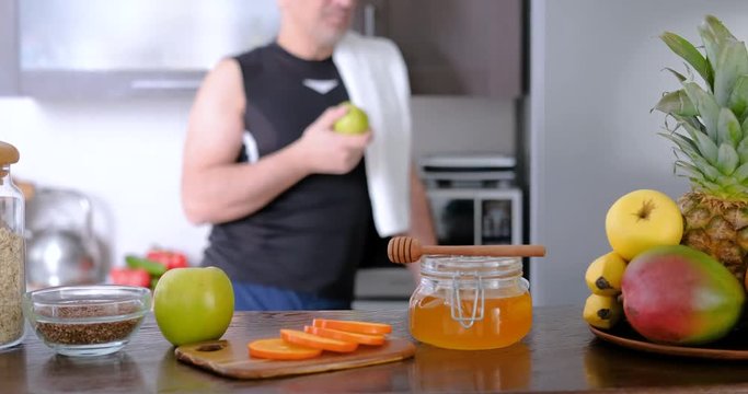 Adult man is eating an apple after a workout.