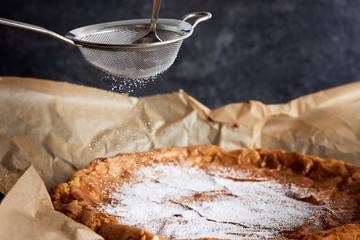 Kuchen wird mit Puderzucker dekoriert