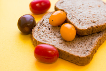 School lunch box. Bread, candies, baby corns, carrot and tomatoes in green plastic container