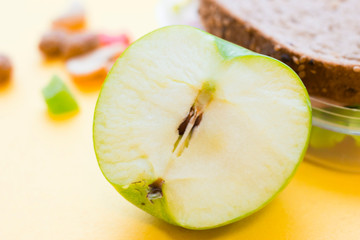 School lunch box. Bread, candies, baby corns, carrot and tomatoes in green plastic container