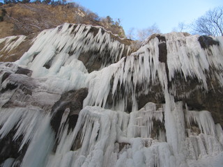 Huge icicles on stone rocks hang over the precipice