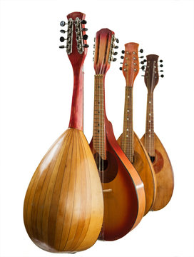 Four different mandolins arranged vertically. Isolated on white background. Selective focus.