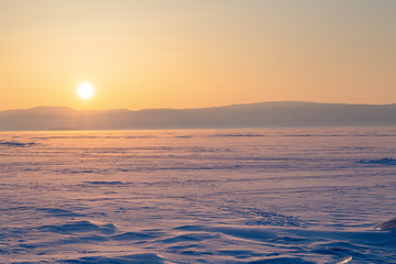 Fototapeta na wymiar Colorful sunset over the crystal ice of Baikal lake