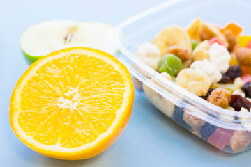 School lunch box. Bread, apple, candies, baby corns, carrot and tomatoes in green plastic container