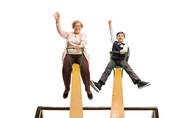 Grandmother and grandson playing on a seesaw