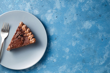 Piece of dark chocolate cake with buttercream, nuts and berry jam