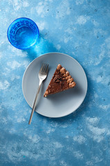 Piece of dark chocolate cake with buttercream, nuts and berry jam