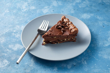 Piece of dark chocolate cake with buttercream, nuts and berry jam