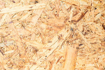 OSB surface texture and background, made of brown wood chips sanded into a wooden chipboard. Close up view of MDF plywood veneer.