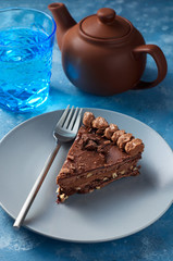 Piece of dark chocolate cake with buttercream, nuts and berry jam