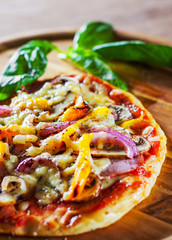 Greek pizza with mushrooms, ham, cheese, onions, pepper on wooden board