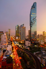 Obraz premium Aerial view Bangkok city metropolis skyline twilight sunset evening time night and modern office condominium with traffic on road beautiful Citiscape in Thailand Asia