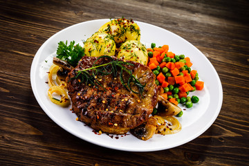 Grilled steak with potatoes and vegetable salad