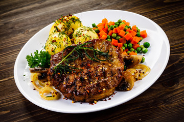 Grilled steak with potatoes and vegetable salad