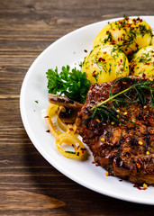 Grilled steak with potatoes and vegetable salad