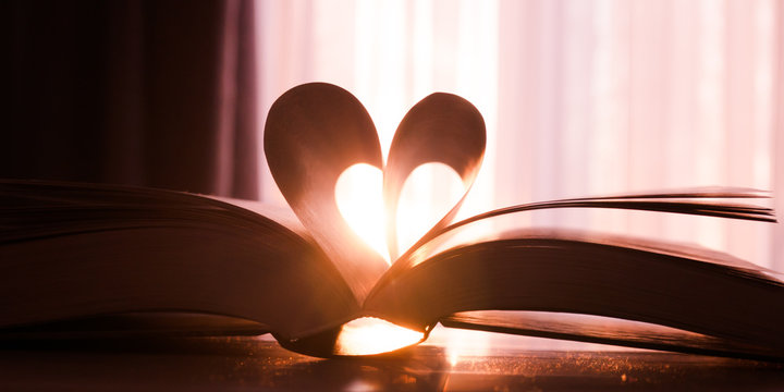 Valentine's day, heart from a book page against a beautiful sunset