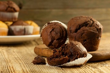 Chocolate muffin, homemade pastry on a wooden background close-up in rustic style