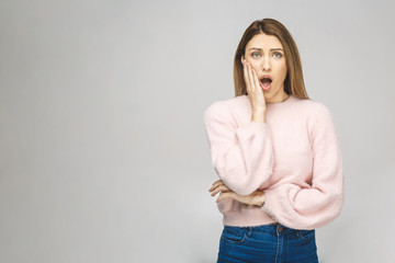 Image of excited screaming young woman standing isolated over white background. Looking at camera.