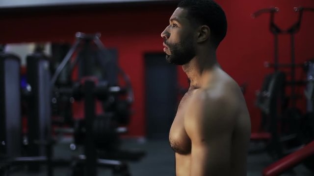 Naked black man is preparing for training in the gym.