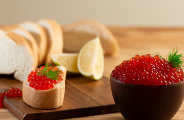 red caviar in a ceramic dish on a wooden background in a rustic style with space for text