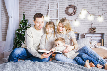 happy family reading a book at home at christmas - Powered by Adobe