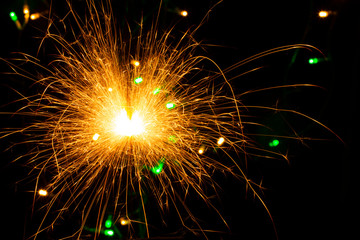 festive background with sparkler and new year lights closeup