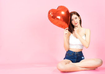 Asian young woman in white bra  red balloon heart. Young woman holding it with  being excited and surprised  holiday present isolated white  background.concept love surprise valentine day..
