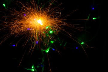 festive background with sparkler and new year lights closeup