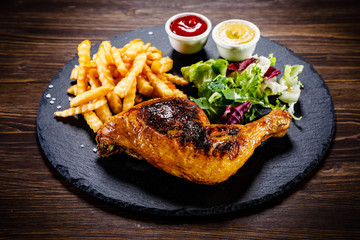 Grilled chicken leg with french fries and vegetables