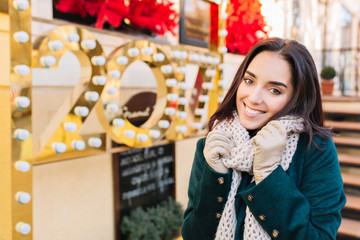 Portrait joyful smiled amazing young woman celebrating new year 2017 on street in city. Cheerful emotions, cozy mood, knitted scarf, smiling to camera, winter holidays time