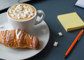 Creative flat lay of workspace desk, composition with notebook, coffe and croissant