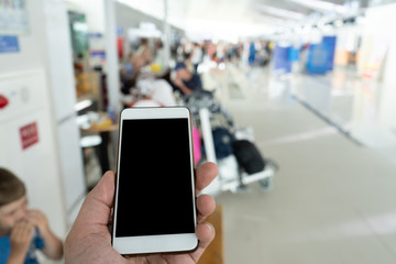 man using digital phone in departure terminal