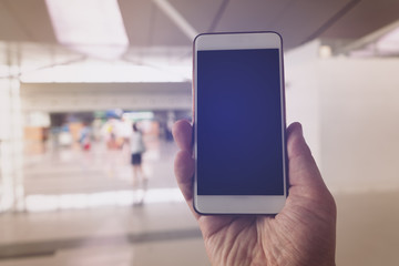 man using smart phone in airport terminal