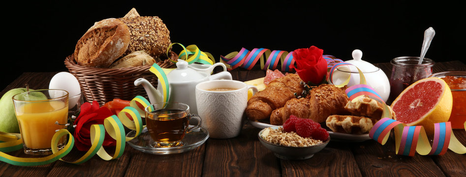 breakfast on table with bread buns, croissants, coffe and juice on carnival