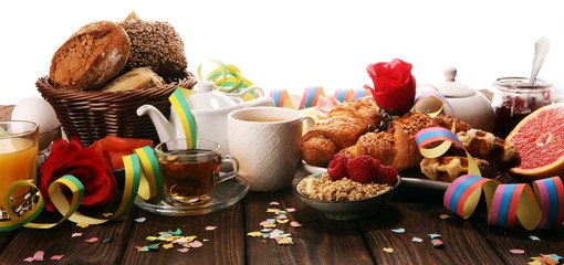 breakfast on table with bread buns, croissants, coffe and juice on carnival
