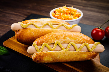 Hot dogs on cutting board on black stone plate