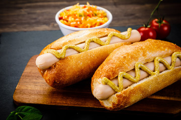 Hot dogs on cutting board on black stone plate