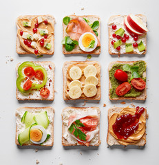 Sandwiches variation with vegetables, fruits, meat, eggs and sweets viewed from above. Variety of...