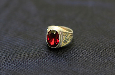 A gemstone ring is a beautiful jewelry on a black cloth.