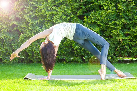 pretty adult woman doing yoga at summer morning
