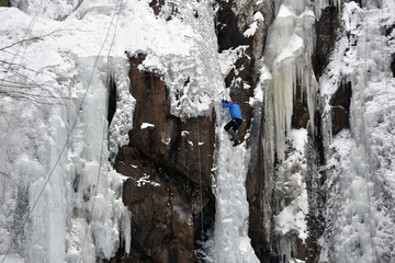 Ice climber on the frozen Boyana Waterfall in Vitosha Mountain near Sofia City, Bulgaria