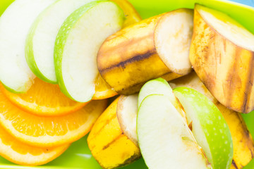 School lunch box. Bread, orange, candies, baby corns, carrot and tomatoes in green plastic container