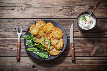 potato pancakes with sour cream on  wooden table
