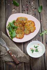 potato pancakes with sour cream on  wooden table