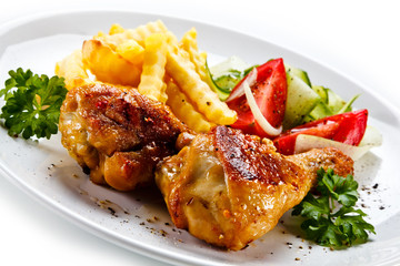 Drumsticks with french fries and vegetable on white background