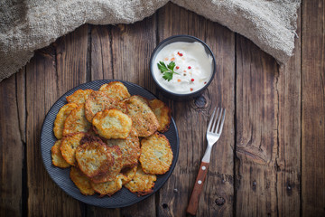 potato pancakes with sour cream on  wooden table